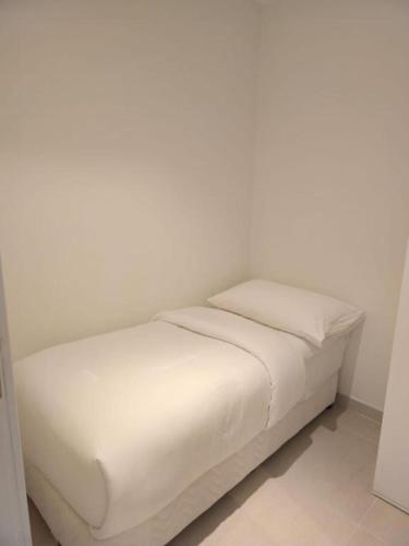 a white bed with two pillows in a room at 3 Bedroom Suite Building-Wide Balcony Fujairah in Fujairah
