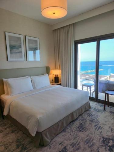 a bedroom with a large bed and a large window at 3 Bedroom Suite Building-Wide Balcony Fujairah in Fujairah