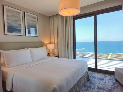 a bedroom with a large bed and a large window at 4 Bedroom Suite Building-Wide Balcony Fujairah in Fujairah