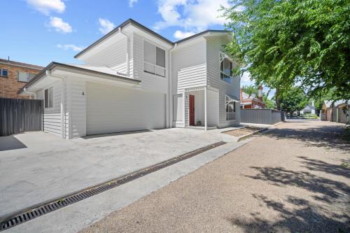 a white house with a large driveway at 'Lumeah' - Apartment 1 Central Wagga in Wagga Wagga