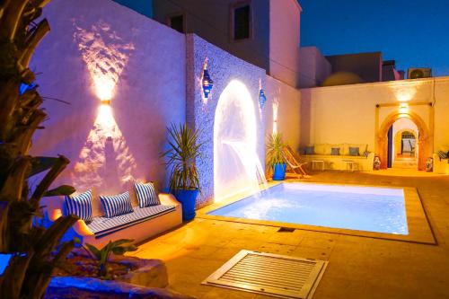 a house with a large swimming pool in a yard at Dar Ayline in Erriadh