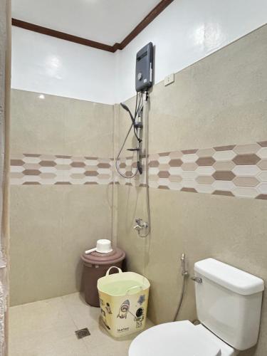 a bathroom with a toilet and a shower at Sinta Stay in El Nido