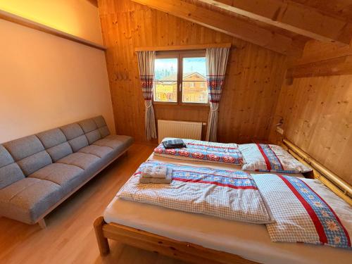 a bedroom with a bed and a couch at Chalet Auszeit Montafon in Bartholomäberg