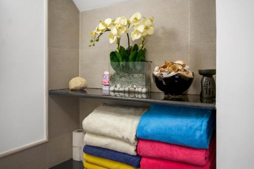 a shelf with towels and a vase with flowers at Luxury Pool Villa Laguna Resort Near Layan Beach - 2 bedrooms 6 people in Layan Beach