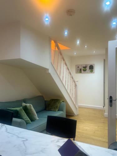 a living room with a couch and a staircase at Zone 2 En-Suite Rooms Peckham Maisonette in London