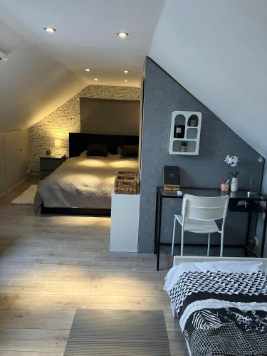 a bedroom with a bed and a desk with a chair at Le Flanelmont in Theux