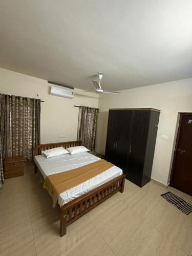 a bedroom with a large bed and a ceiling at Ironwood Villa in Cochin
