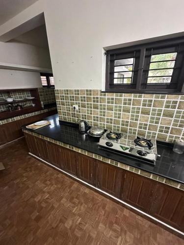 a kitchen with a counter with a stove top at Ironwood Villa in Cochin