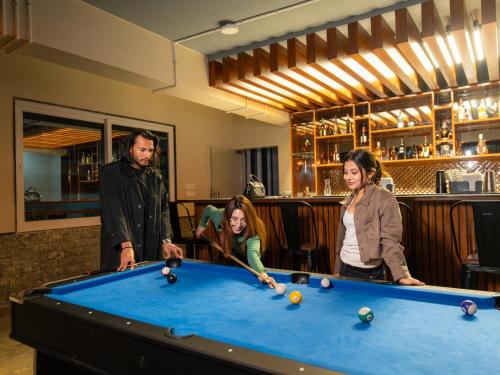 甘托克Moustache Hostel Gangtok的一群人站在台球桌旁