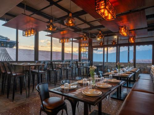 甘托克Moustache Hostel Gangtok的一间有桌椅、可欣赏海景的餐厅