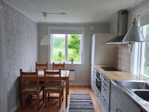 una cocina con mesa y sillas y una ventana en Small Cottage, en Jönköping