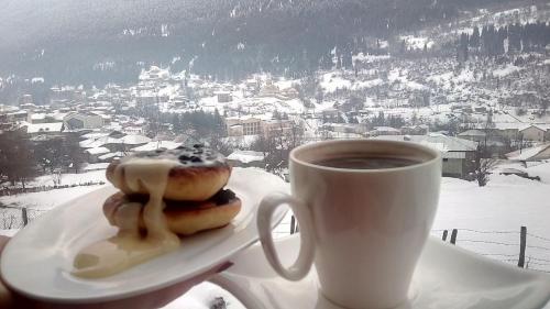 梅斯蒂亚Roza Mountain View Guesthouse的盘子上装有甜甜圈和咖啡