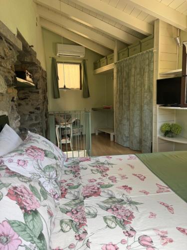 a bedroom with a bed with a floral bedspread at Castagna Holiday Home in Nesso