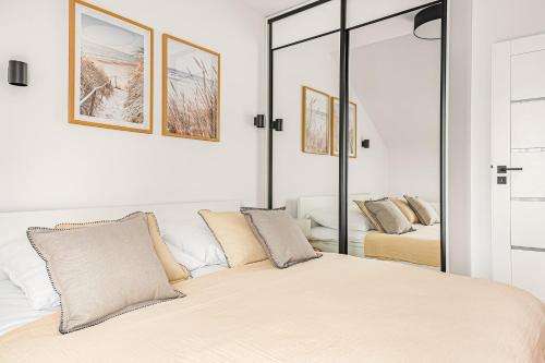 a white bedroom with a large bed and mirrors at Cortaderia Haven - SPA - Basen, Jacuzzi, Sauna & Parking in Ustronie Morskie