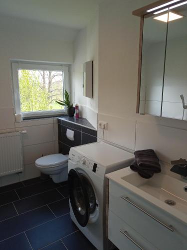 a bathroom with a washing machine and a toilet at Ferienwohnung Nr 2 am Hambach in Falkenbach