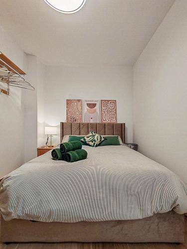 a bedroom with a large bed with green pillows at Black Lion in Villena