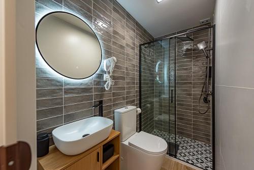 Un baño con inodoro, lavabo y espejo. en Black Lion, en Villena