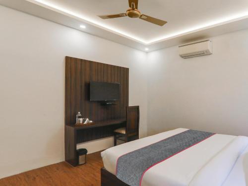 a bedroom with a bed and a flat screen tv at Super Hotel O Centrum in Gorakhpur