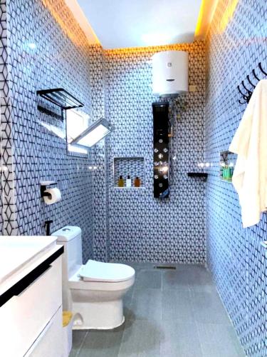 a blue tiled bathroom with a toilet and a sink at Eden- Jacuzzi Privé et Terasse à 5mn de la plage in Dakar