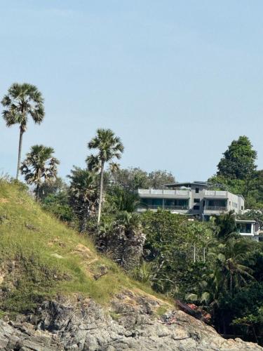 a house on top of a hill with palm trees at Seaview Eagles Nest Apartments in Rawai Beach