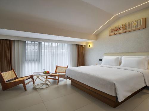 Un dormitorio con una cama grande y una mesa y sillas. en Zhangjiajie JoyMaple Hotel, en Zhangjiajie