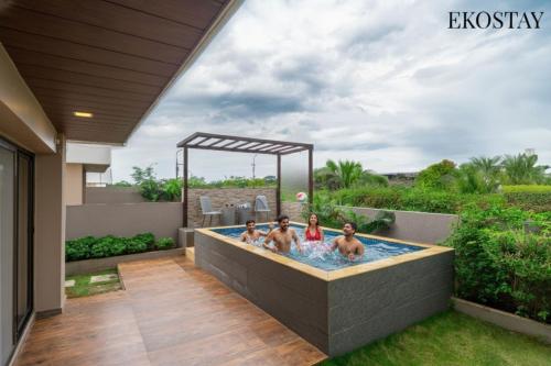 EKOSTAY - Kara Villa في كارجات: مجموعة من الناس في حوض استحمام ساخن في الفناء الخلفي