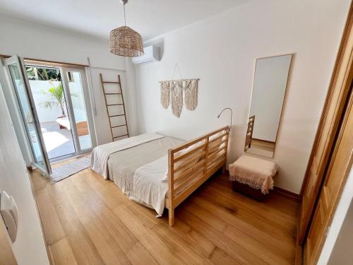 a bedroom with a bed and a mirror at Miguel Surf House in Costa da Caparica