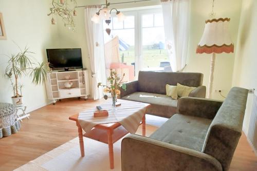 un soggiorno con un divano e un tavolo di Ferienhof Landfrieden a Vollerwiek