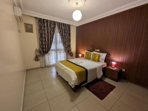 Una cama o camas en una habitación de Appart'hôtel Micheline Suites & SPA, Bastos