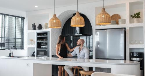 坎古Kiara Ocean Place的站在厨房柜台的男女