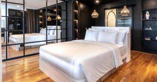 a bedroom with two white beds and mirrors at Kiara Ocean Place in Canggu