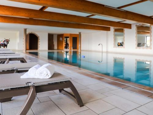 einen Pool mit einer Reihe von Stühlen und einem Pool in der Unterkunft Studio Domaine des Reines by Interhome in Nendaz