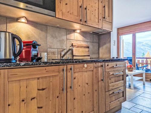 eine Küche mit Holzschränken und einer Arbeitsplatte in der Unterkunft Studio Domaine des Reines by Interhome in Nendaz