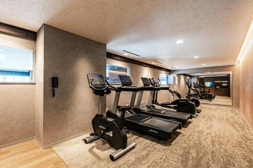 a gym with a row of treadms and cardio machines at The Gate Hotel Sapporo by Hulic in Sapporo