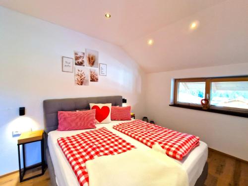 1 dormitorio con 1 cama grande con mantas rojas y blancas en Apartment Wildschütz by Interhome, en Pill