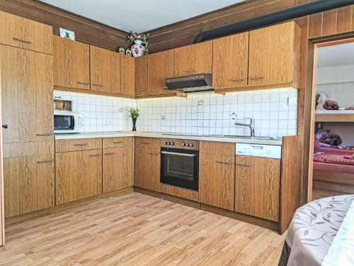 Apartment Appartement 1 by Interhome في روسباخ أم باس غشوت: مطبخ مع خزائن خشبية ومغسلة