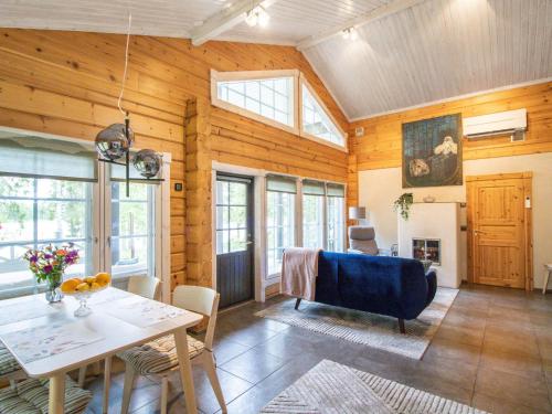 a living room with a table and a blue couch at Holiday Home Villa white water by Interhome in Kainuu