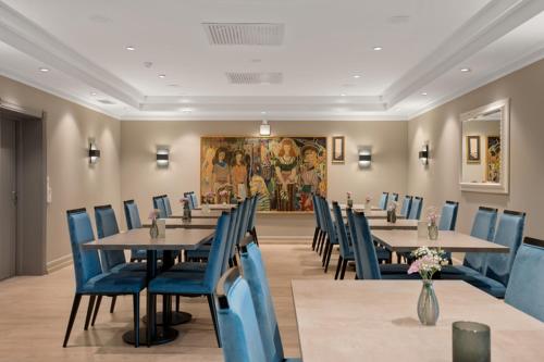 Un comedor con mesas y sillas azules. en Thon Partner Hotel Saga, en Haugesund