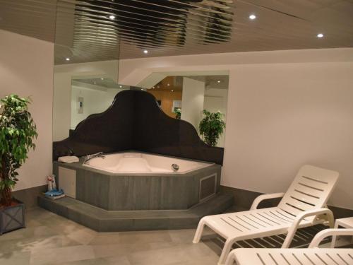 a large bathroom with a tub and two chairs at Apartment Dominic B2 by Interhome in Saas-Fee