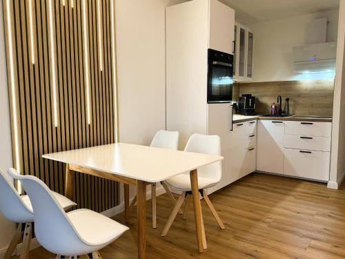 een kleine keuken met een witte tafel en stoelen bij Neu! Hirschgrund 10 OG Panorama, Sauna, Pool in Braunlage