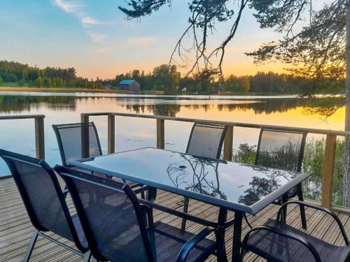 a table and chairs on a dock near a lake at Holiday Home Louhikko by Interhome in Houhajärvi