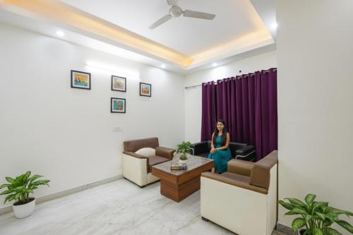 uma mulher em pé numa sala de estar em FabHotel Comfy Cottage em Gurgaon
