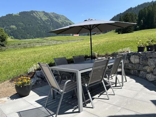 a table and chairs with an umbrella on a patio at Apartment Alpenchalet Haldeli Dachwohnung by Interhome in Gstaad