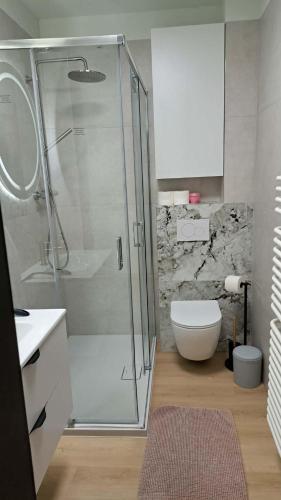 a bathroom with a glass shower and a toilet at Apartament 325 in Bešeňová