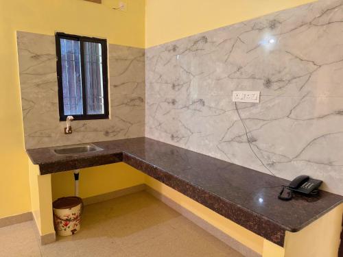 ein Badezimmer mit einem Waschbecken und einem Telefon auf einer Ablage in der Unterkunft Studio 402 Continental stay in Deoghar