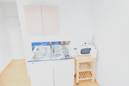 a kitchen with white appliances on a counter at Studio place Victor Hugo in La Celle-sous-Gouzon