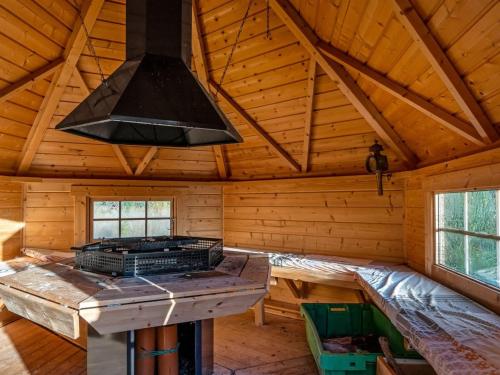 a kitchen with a stove in a log cabin at Holiday Home Emelia - 4-2km from the sea by Interhome in Byrum