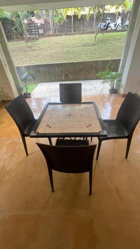 two chairs and a wooden table with a table and chairs at Nisarg in Canacona
