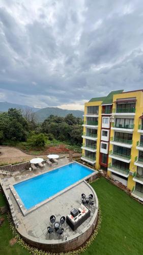 an overhead view of a swimming pool next to a building at Nisarg in Canacona