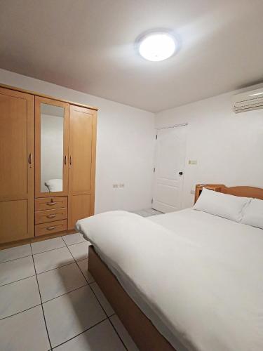 a bedroom with a large white bed and wooden cabinets at Townhome 45 in Ban Nong Pru